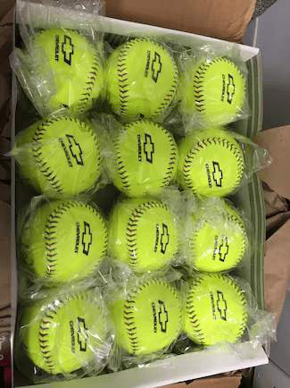 Twelve individually wrapped neon yellow softballs with black Chevrolet logos and stitching, arranged in a box.